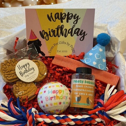 Birthday gift basket for pets with treats, ball, and card on a white background
