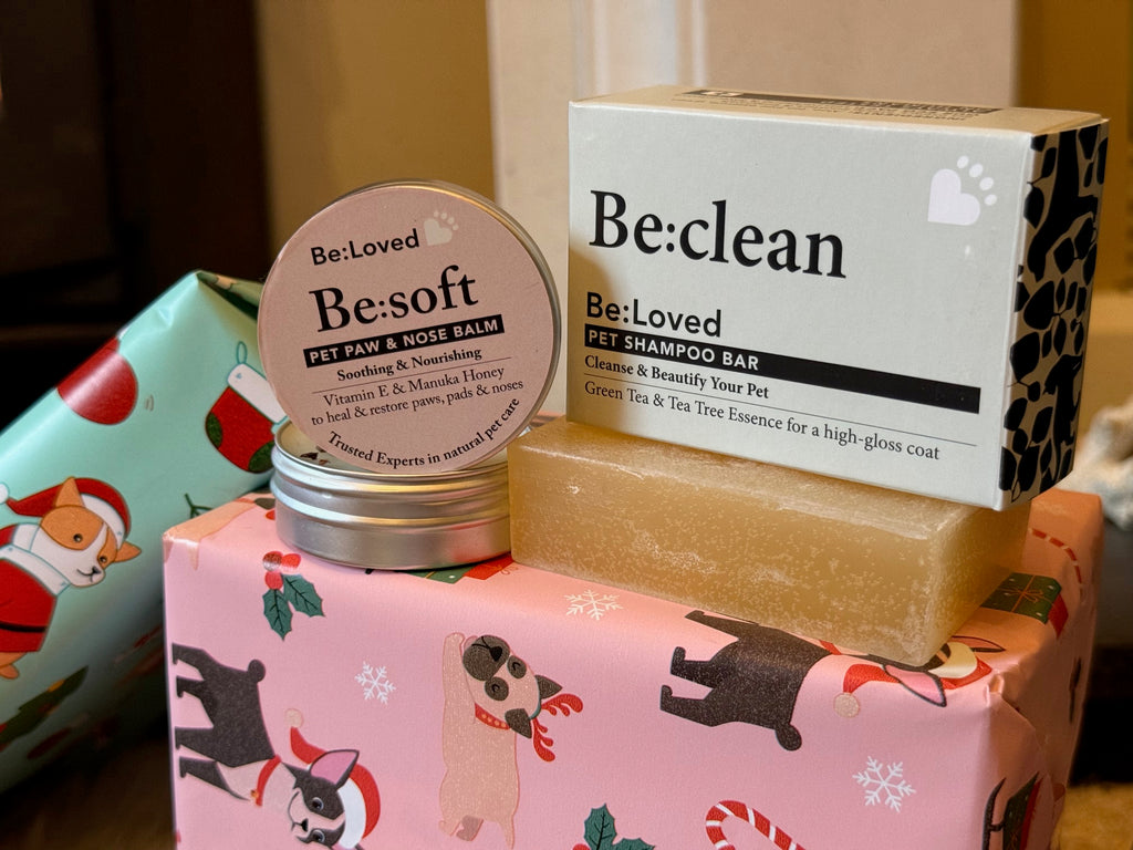 Pet care products including a balm, shampoo bar, and soap on a decorative box with dog illustrations.