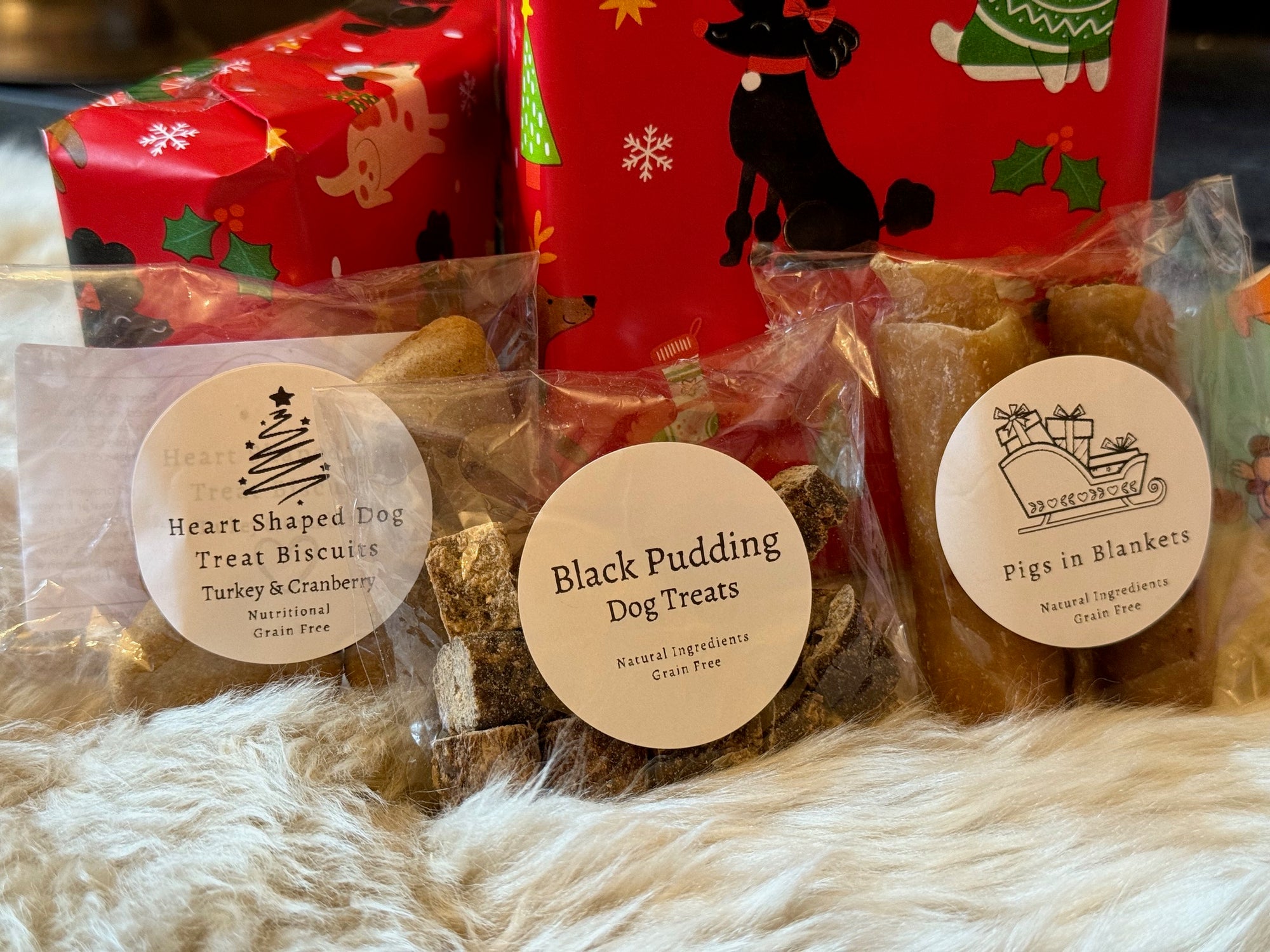 Dog treats in clear packaging with branded labels on a fluffy white surface.