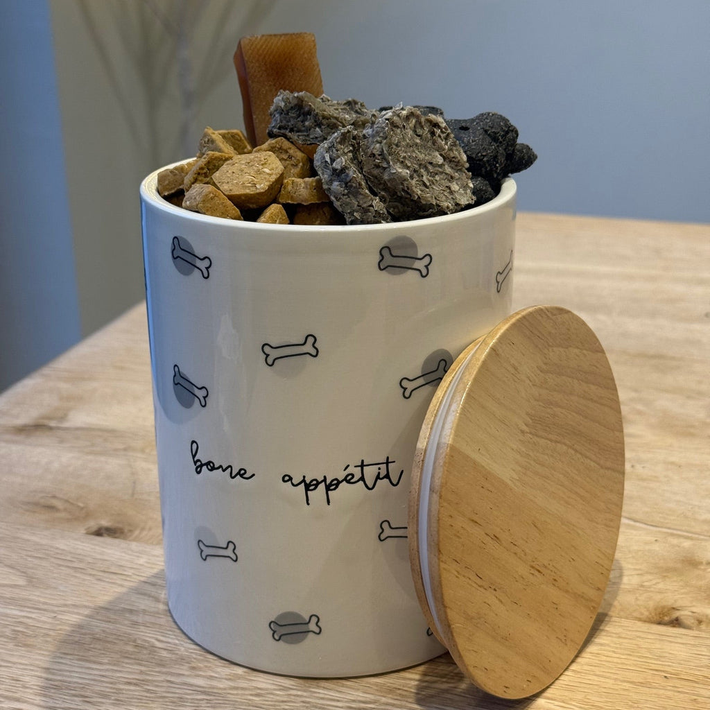 "bone appetit" treat jar with black and gray dog bone print jar filled with dog treats 