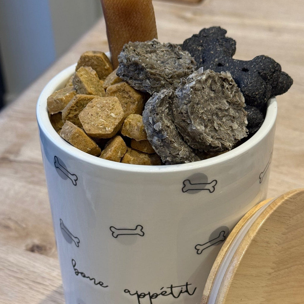 "bone appetit" treat jar with black and gray dog bone print jar filled with dog treats 