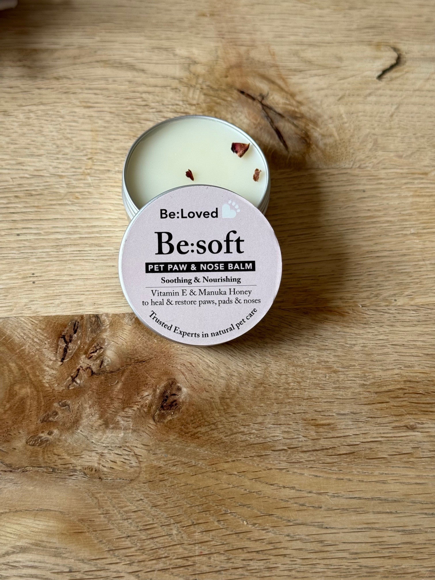 Pet paw and nose balm with 'Be:Loved Be:soft' label on a wooden surface
